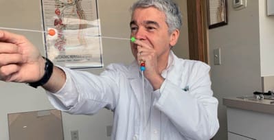 Stroke survivor Gregory Symko, D.C., demonstrates a tool that helps patients improve their balance and coordination.